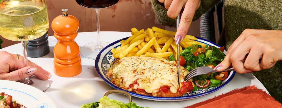 Someone eating pasta and a salad at Prezzo