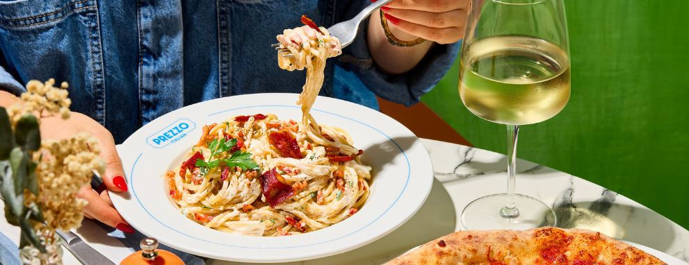 Someone eating pasta and a salad at Prezzo